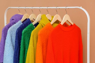 Renkli elbiseli askılar duvarın yanında asılı, yakın plan.