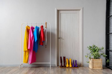 Renkli elbiselerle, şemsiyeyle ve kapının yanındaki lastik botlarla doldur.