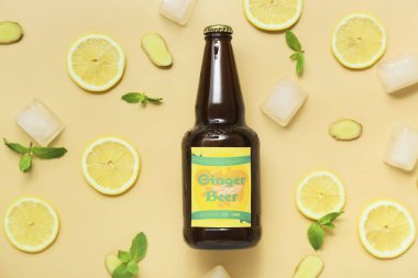 Taze zencefilli bira, nane şekeri, limon dilimleri ve bej arka planda buz küpleriyle kompozisyon