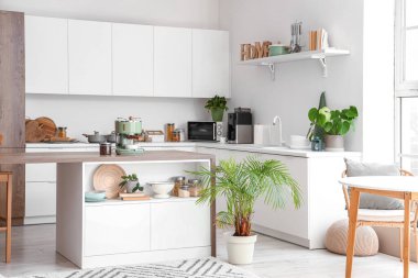 Ahşap masasında kahve makinesi olan modern mutfağın içi.