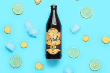 Taze zencefilli bira, limon dilimleri ve mavi arka planda buz küpleriyle kompozisyon