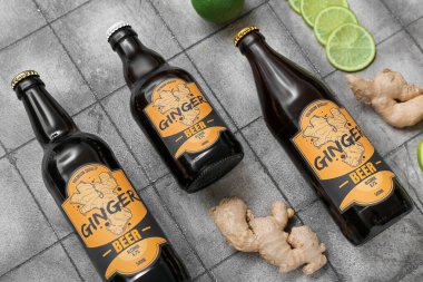 Gri fayanslı arka planda taze zencefilli bira ve limon dilimleri içeren kompozisyon, yakın plan.