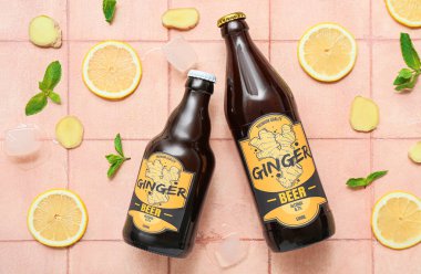 Taze zencefilli bira, nane, limon dilimleri ve bej arka planda buz küpleriyle kompozisyon