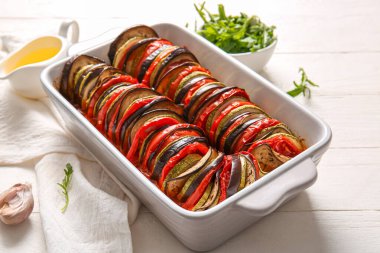 Beyaz ahşap arka planda lezzetli Ratatouille yemeği pişirmek.