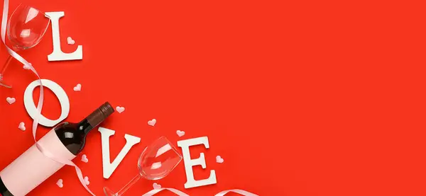 Bottle of wine, glasses, word LOVE and hearts on red background with space for text. Valentine\'s Day celebration