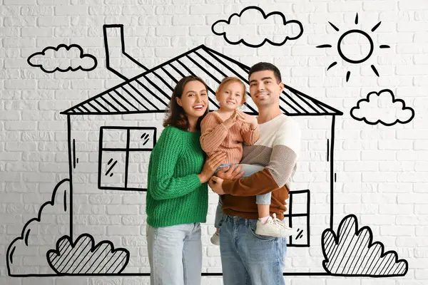 Happy family dreaming about their new house on white brick background