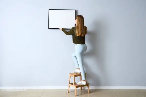 Young Woman Hanging Blank Frame Light Wall Home — 스톡 사진