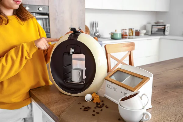 Woman making coffee in kitchen
