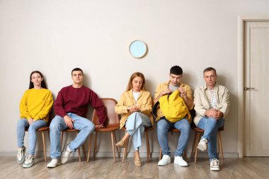 İnsanlar odalarında sıralarını bekliyorlar.