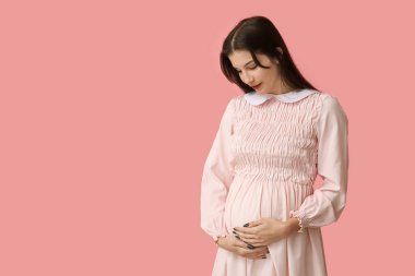 Mutlu hamile kadın pembe arka planda