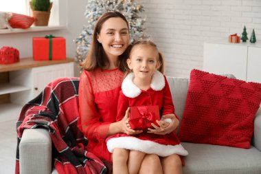 Mutlu anne ve küçük kızı evde Noel hediyesiyle