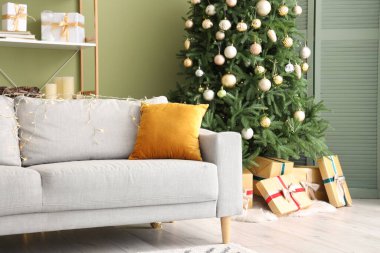 Rahat bir kanepe, Noel ağacı ve oturma odasında hediyeler.