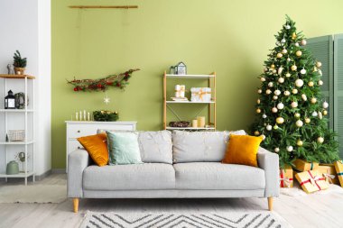 Rahat kanepesi ve Noel ağacı olan modern bir oturma odası.