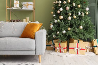 Rahat bir kanepe, Noel ağacı ve oturma odasında hediyeler.
