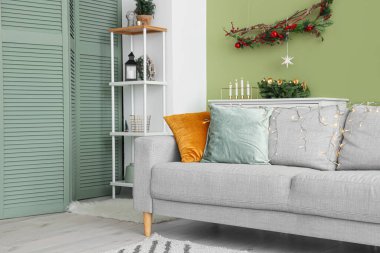 Kanepenin üzerinde parlayan Noel ışıkları olan modern oturma odasının şık bir iç mekanı.