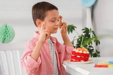 Tatlı pastalı şirin çocuk evde doğum günü dileği diliyor.