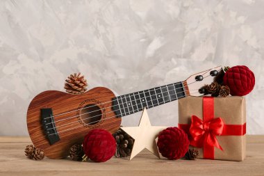 Ukulele ile kompozisyon, Noel hediyesi ve ahşap masa üzerindeki süslemeler grunge arka plan