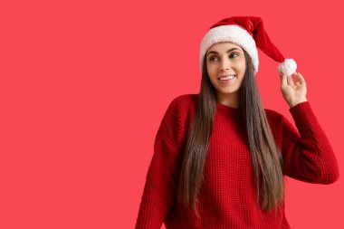 Noel Baba şapkası kırmızı zemin üzerine genç kadın