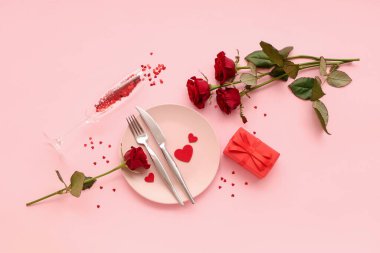 Kırmızı güller, hediye kutuları ve pembe arka planda kalpleri olan güzel bir masa. Sevgililer Günü kutlaması