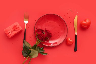 Kırmızı güller, hediye kutuları ve renk arkaplanlı kalplerle dolu güzel bir masa. Sevgililer Günü kutlaması