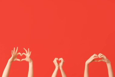 Kırmızı arka planda kalp hareketi gösteren kadın elleri. Sevgililer Günü kutlaması