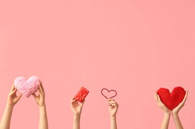 Kumaş kalpli kadın eller ve pembe arka planda hediye kutusu. Sevgililer Günü kutlaması