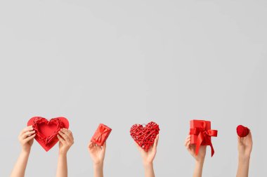 Kalpli kadın elleri ve gri arka planda hediye kutuları. Sevgililer Günü kutlaması