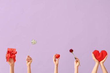 Farklı kalpleri olan kadın elleri, kırmızı gül ve leylak arkaplanlı hediye kutusu. Sevgililer Günü kutlaması