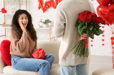 Sevgililer Günü 'nde evde sevgilisini selamlayan bir adam.