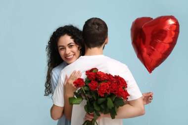 Sevgililer Günü 'nde mavi arka planda sevgilisini selamlayan adam.