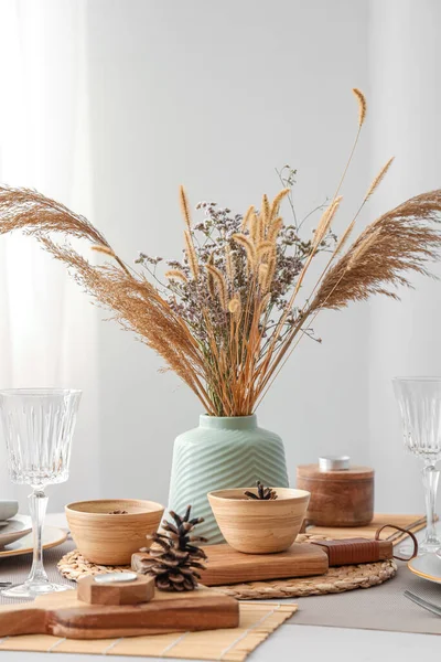 Elegant table setting with dried flowers, pampas grass and pine cones