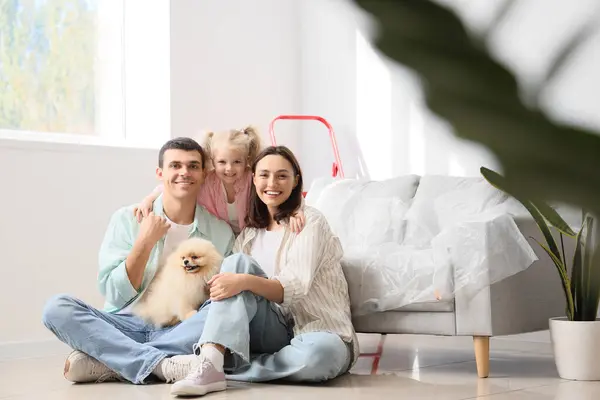 Happy family sitting on floor during repair of their new house