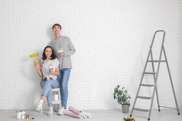 Young couple with painting tools during repair in their new house