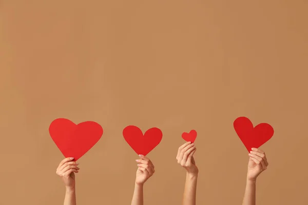 Kahverengi Arka Planda Kırmızı Kağıt Kalpli Kadın Elleri Sevgililer Günü — Stok fotoğraf