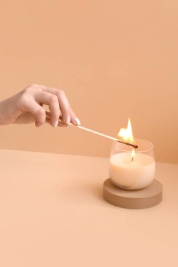 Soluk turuncu arka planda mum yakan kadın
