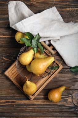 Tahta zemin üzerinde olgun armutlar olan sepet.