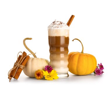 Tarçınlı balkabaklı latte ve beyaz arka planda güzel çiçekler.