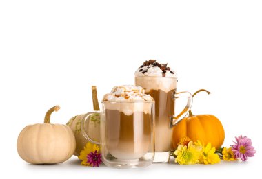 Bir bardak lezzetli balkabaklı latte, yıldız anason ve beyaz arka planda güzel çiçekler.