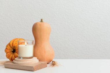 Balkabakları, mum ve kitaplarla dolu bir sonbahar masasında