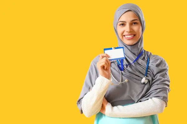 Joven Médico Musulmán Con Placa Sobre Fondo Amarillo —  Fotos de Stock