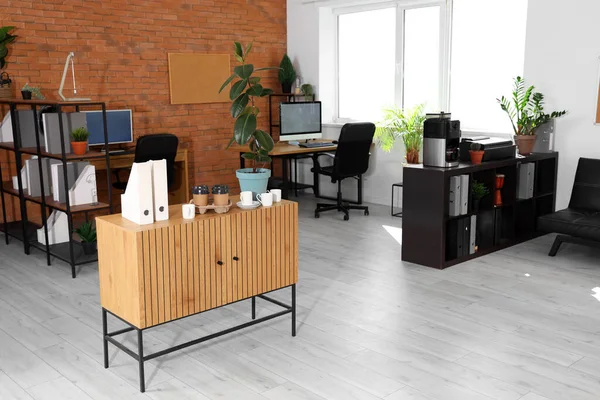 Interior of modern office with coffee machine and workplaces