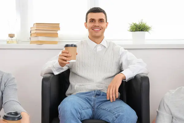 Young man having coffee break in office