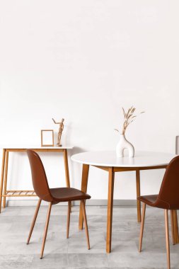 Beyaz masa, aydınlık oturma odasının iç tarafında otlar var.