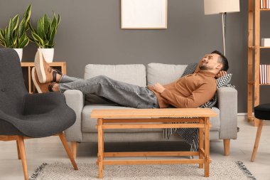 yakışıklı adam evde kanepede yatan