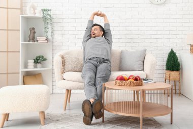 Oturma odasındaki kanepede dinlenen yakışıklı adam.