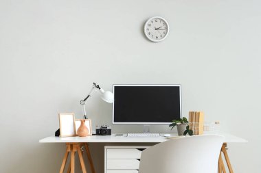 Modern bilgisayar ve ışık duvarının yanında fotoğraf makinesi olan şık bir iş yeri.