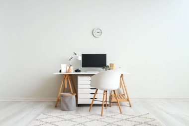 Modern bilgisayar ve ışık duvarının yanında fotoğraf makinesi olan şık bir iş yeri.
