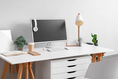 Işık duvarının yanında modern bilgisayarla rahat bir iş yeri