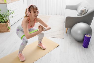 Evde elastik bantla kulaklık takan genç bir bayan.