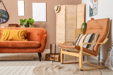 Şık oturma odasının içinde yumuşak yastıklı turuncu kanepe ve koltuk.